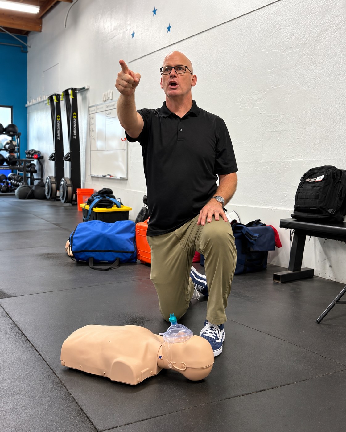 Instructor leading a CPR training session with a manikin in front of the class.